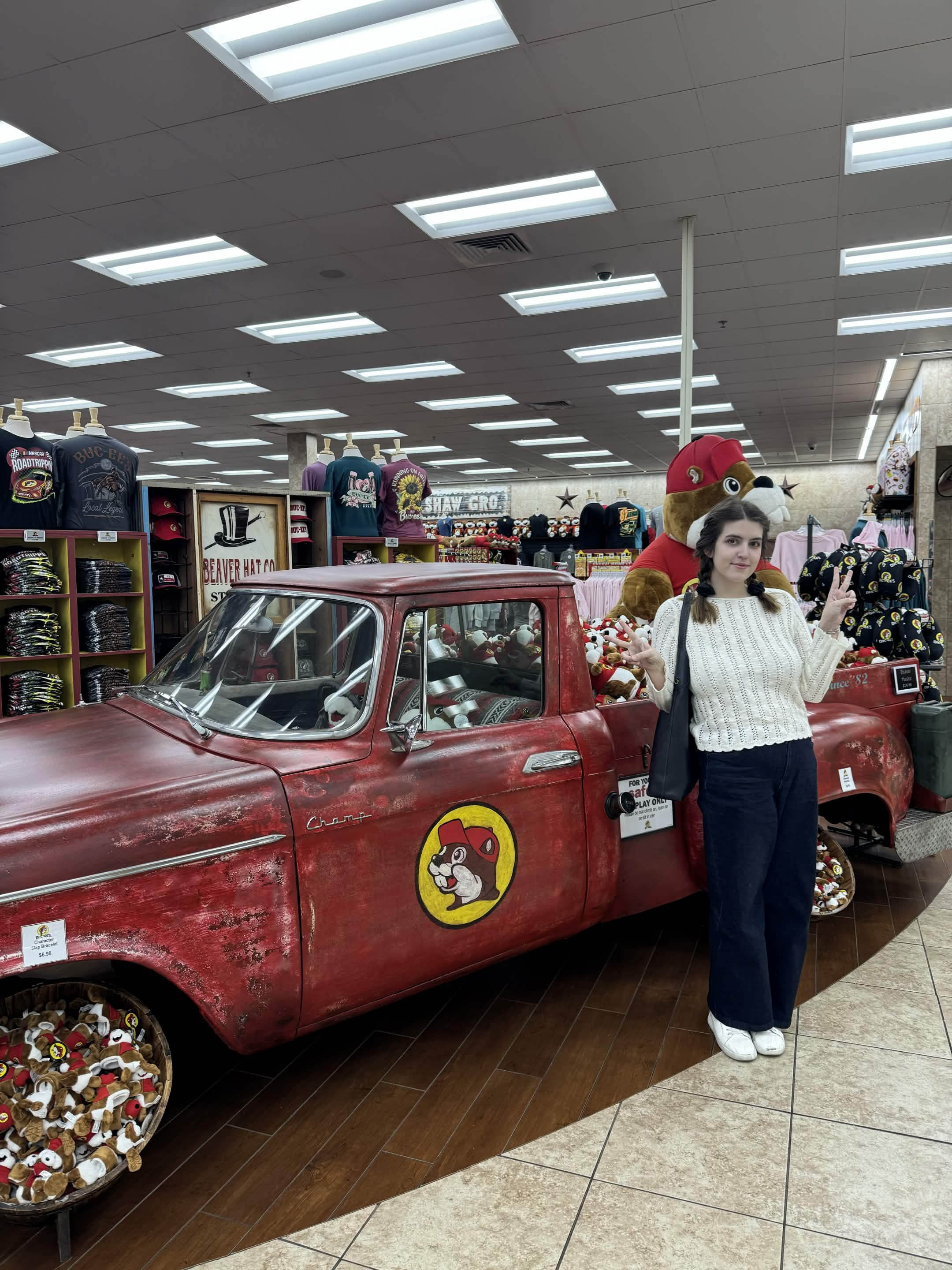 A playful moment posing beside a red Buc-ee's truck